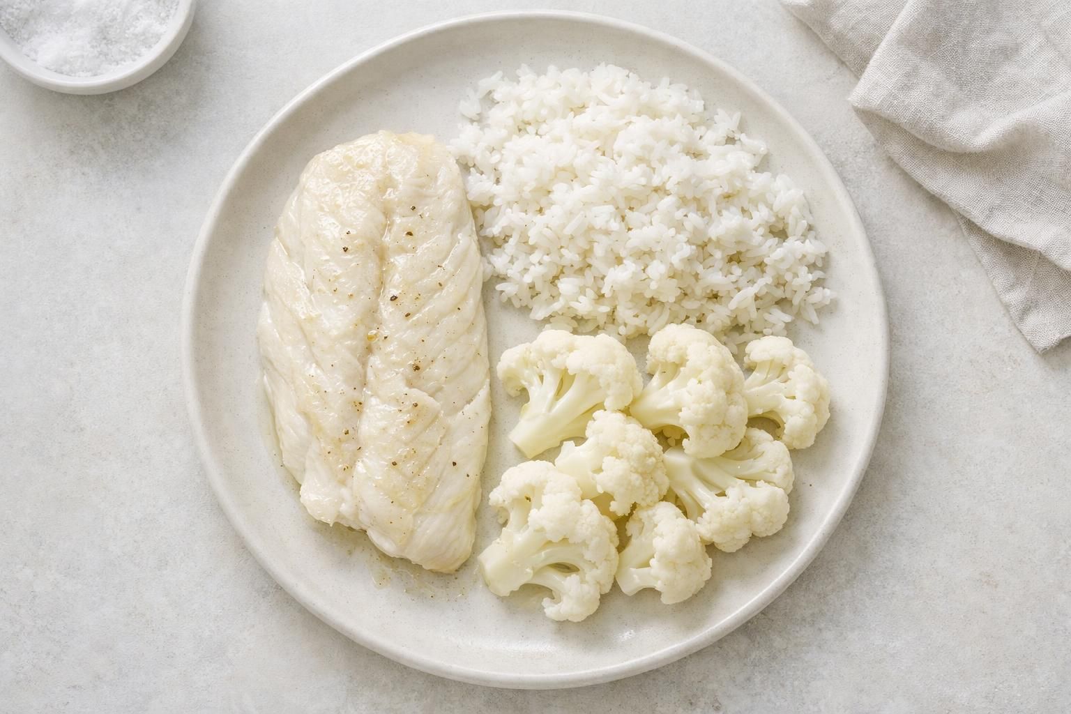 Assiette de régime blanc : poisson blanc, riz et chou-fleur après un blanchiment